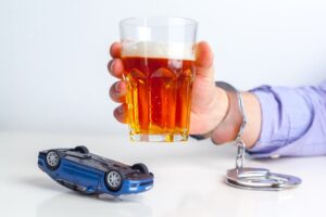 Drunk Driving Concept: Beer, Car Keys, and Handcuffs.